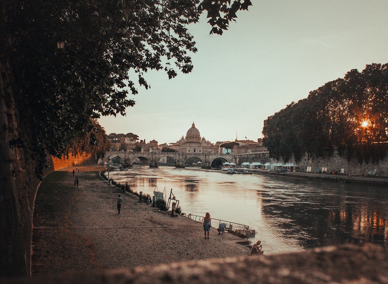 View of St. Peter’s Basilica and the Tiber River at sunset in Rome, a hidden gem perspective away from the crowds.