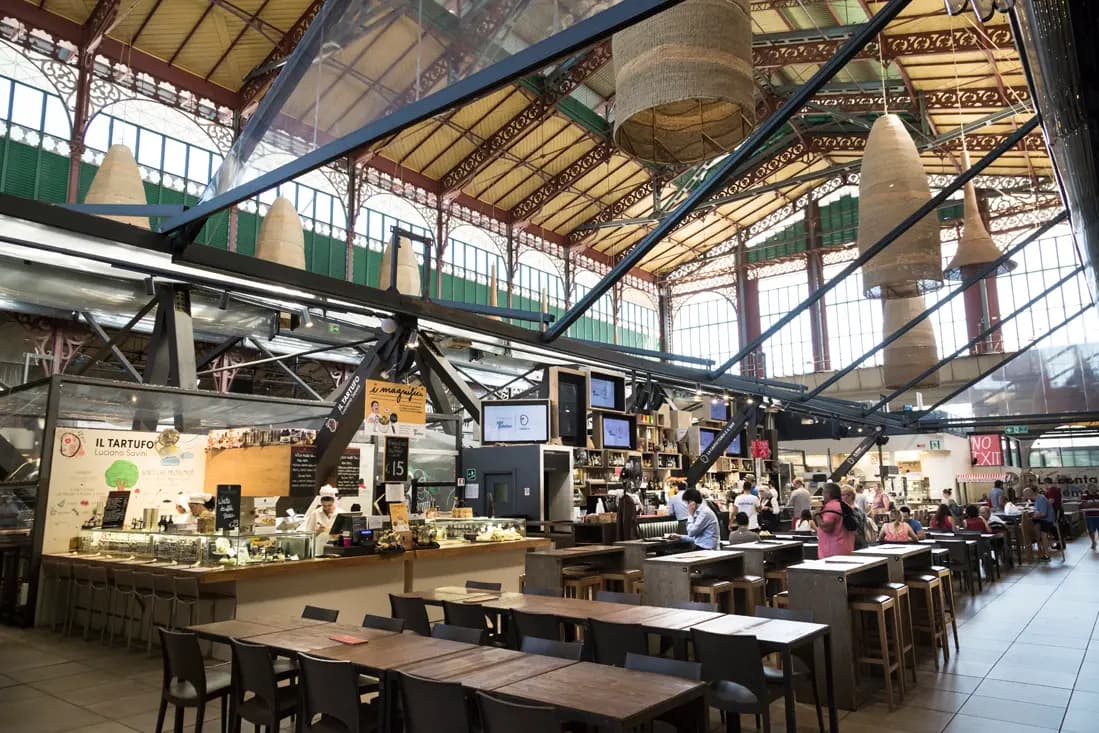 Interior of Florence Central Market with food stalls, local vendors, and visitors enjoying authentic Italian cuisine experiences.