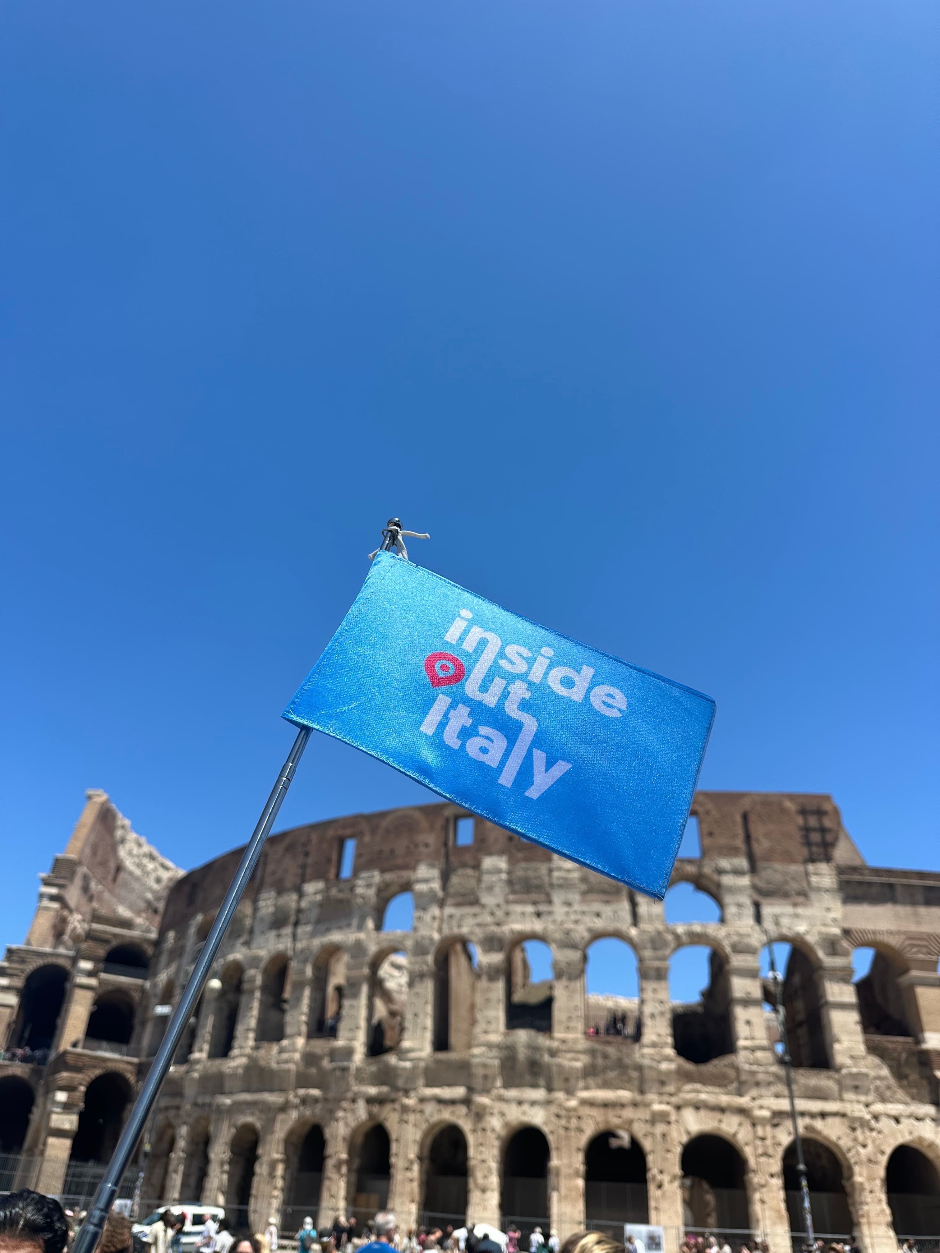 The Inside Out Italy flag raised in front of the Colosseum