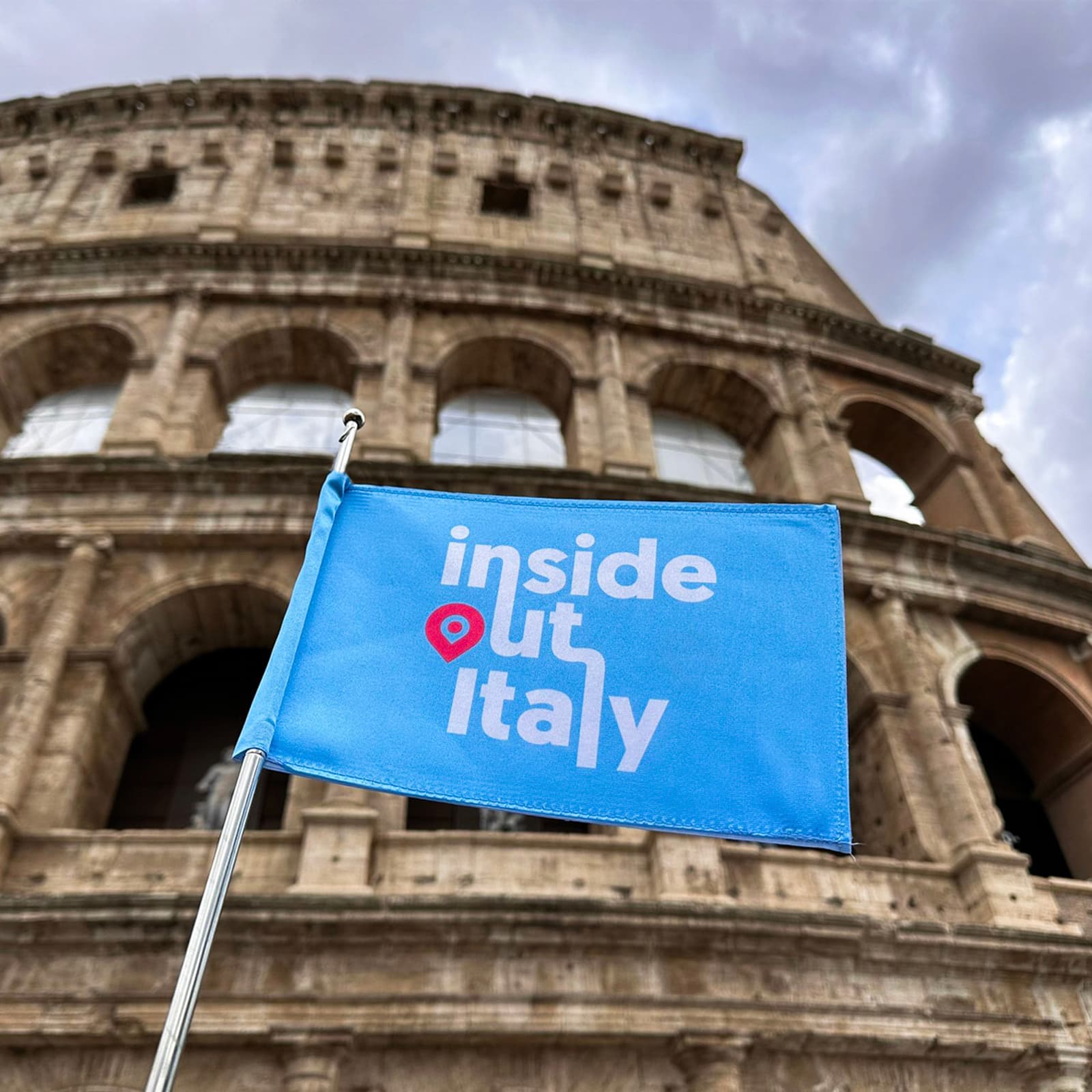 The Inside Out Italy flag in front of the Colosseum